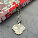 shinigami logo necklace laying on a manga book